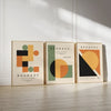Three framed abstract geometric canvas prints featuring muted earth tones and black on a light background.