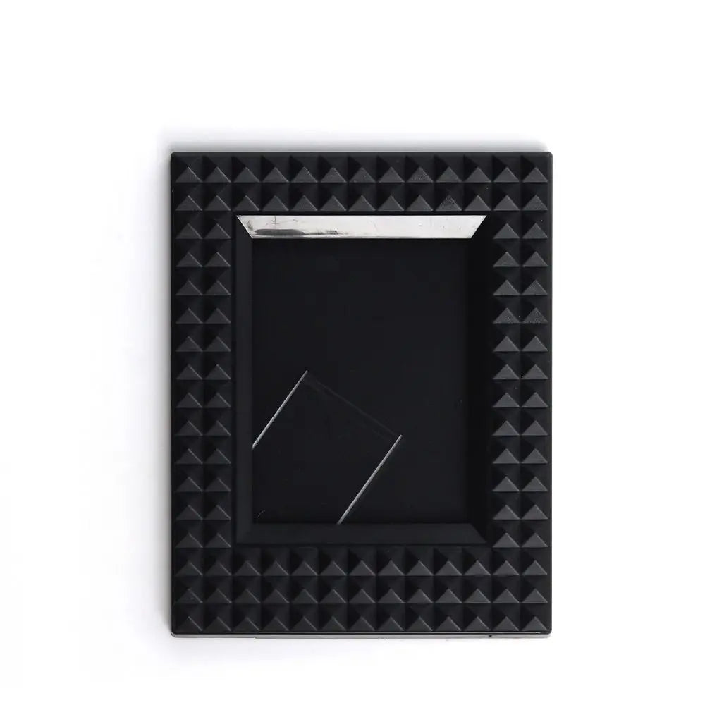 A black square film frame with a silver border and a recessed area for instant photos.