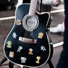 A black electric guitar features a decorative sticker pack of watercolor animal illustrations on its body.