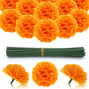 A pile of bright orange silk marigold flowers used for Dia de los Muertos and fall decor, next to a bundle of green stems.