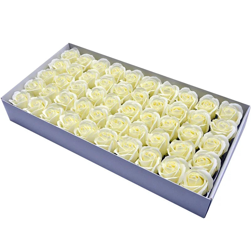 A rectangular box filled with numerous cream-colored artificial rose heads for wedding and party decor.