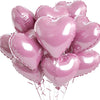 A bunch of pink heart-shaped foil balloons tied together, ready for parties and celebrations.