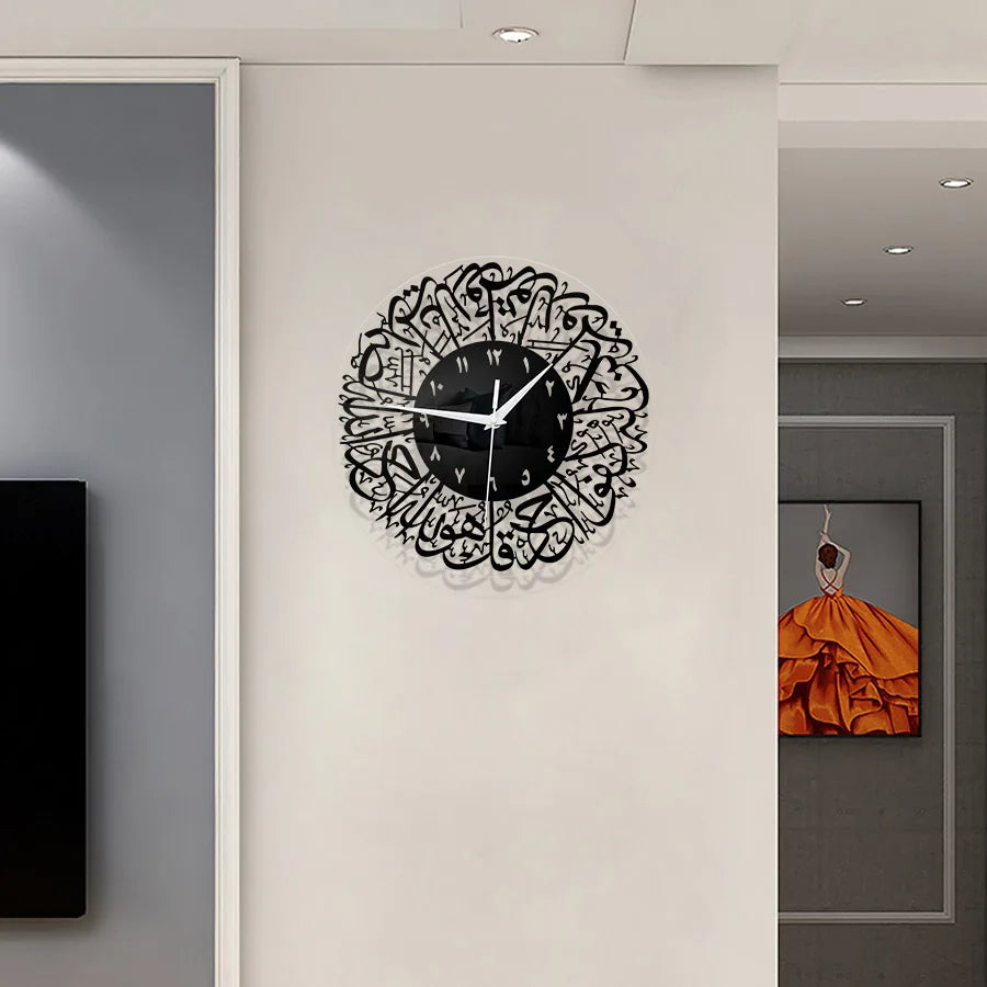 A black acrylic wall clock featuring intricate Arabic calligraphy design on a white background.