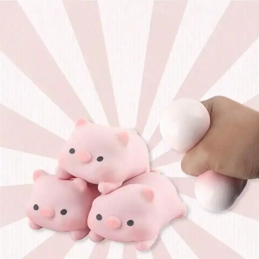 A hand is holding several adorable pink pig mochi squishy stress relief toys against a light pink striped background.