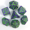 A set of seven polyhedral dice in various shades of purple and green resting on a white surface.