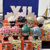 A collection of Jujutsu Kaisen blind box collectible figures in various poses and colors displayed in their packaging.