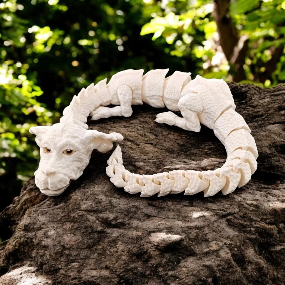 Figurine de dragon peinte à la main, blanche et réaliste, en forme de serpent enroulé, repose sur une roche sombre.