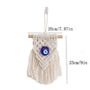 Macrame wall hanging featuring a white fringe and a blue evil eye pendant, suspended by a cord.