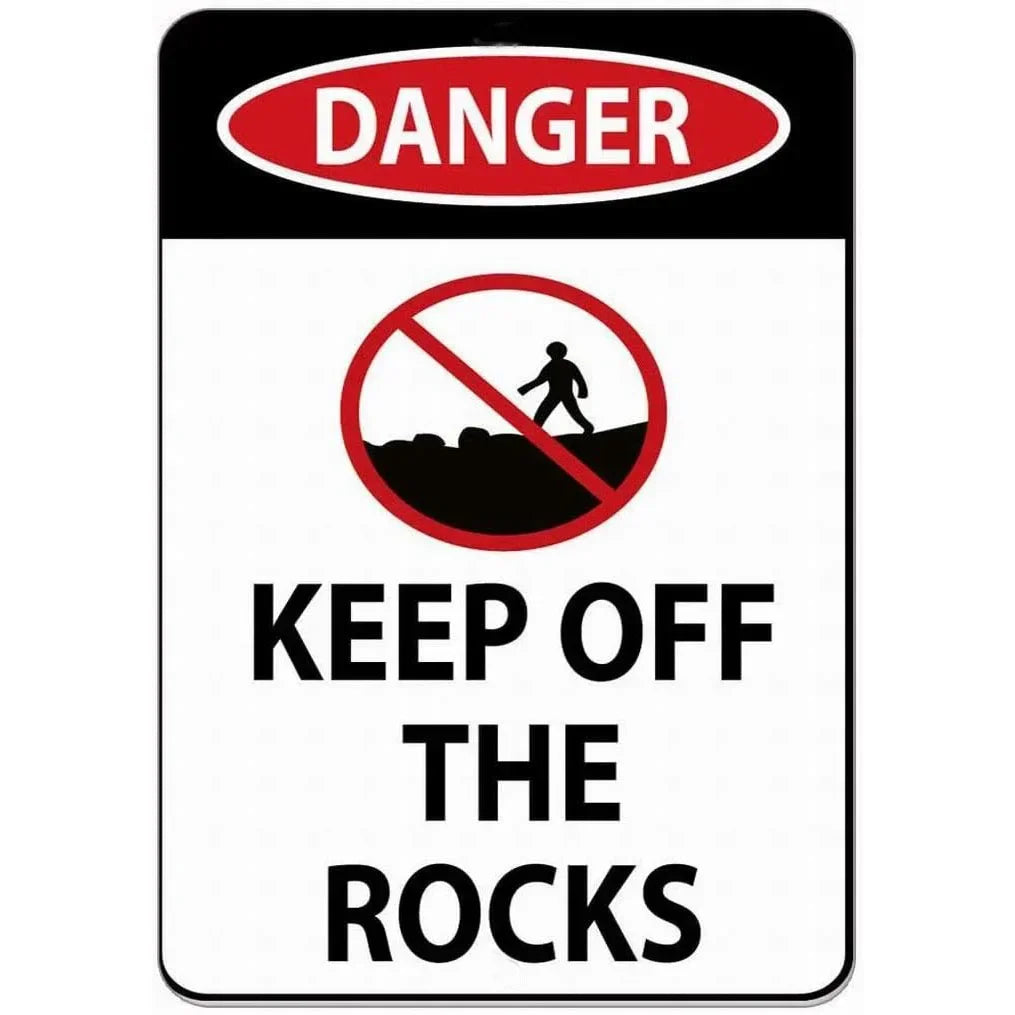 A vintage red and white warning sign that says DANGER and KEEP OFF THE ROCKS.