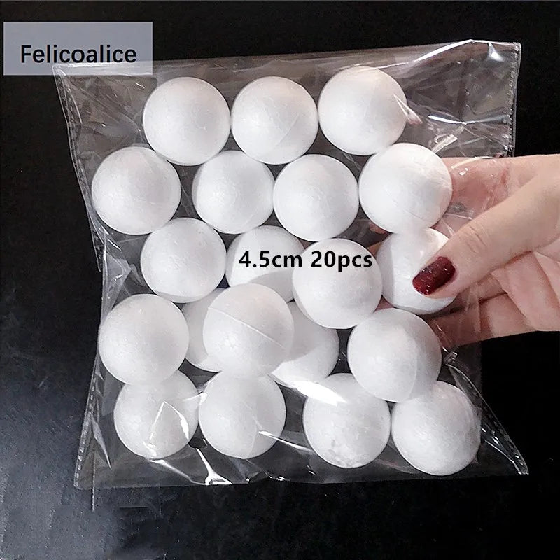 A hand holds a clear plastic bag filled with 20 white polystyrene foam balls for crafting.