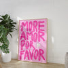 Pink canvas wall art featuring the text MORE AMOR POR FAVOR on a light wood frame