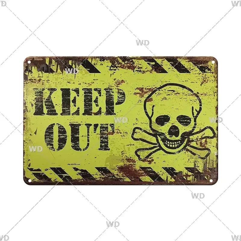 A vintage yellow metal sign with black text that reads KEEP OUT and features a skull and crossbones design.