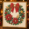 A framed diamond painting featuring a red and green Christmas wreath with pearls and gold accents.