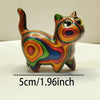 Hand-painted wooden sculpture of a cat with multi-colored stripes and large eyes.