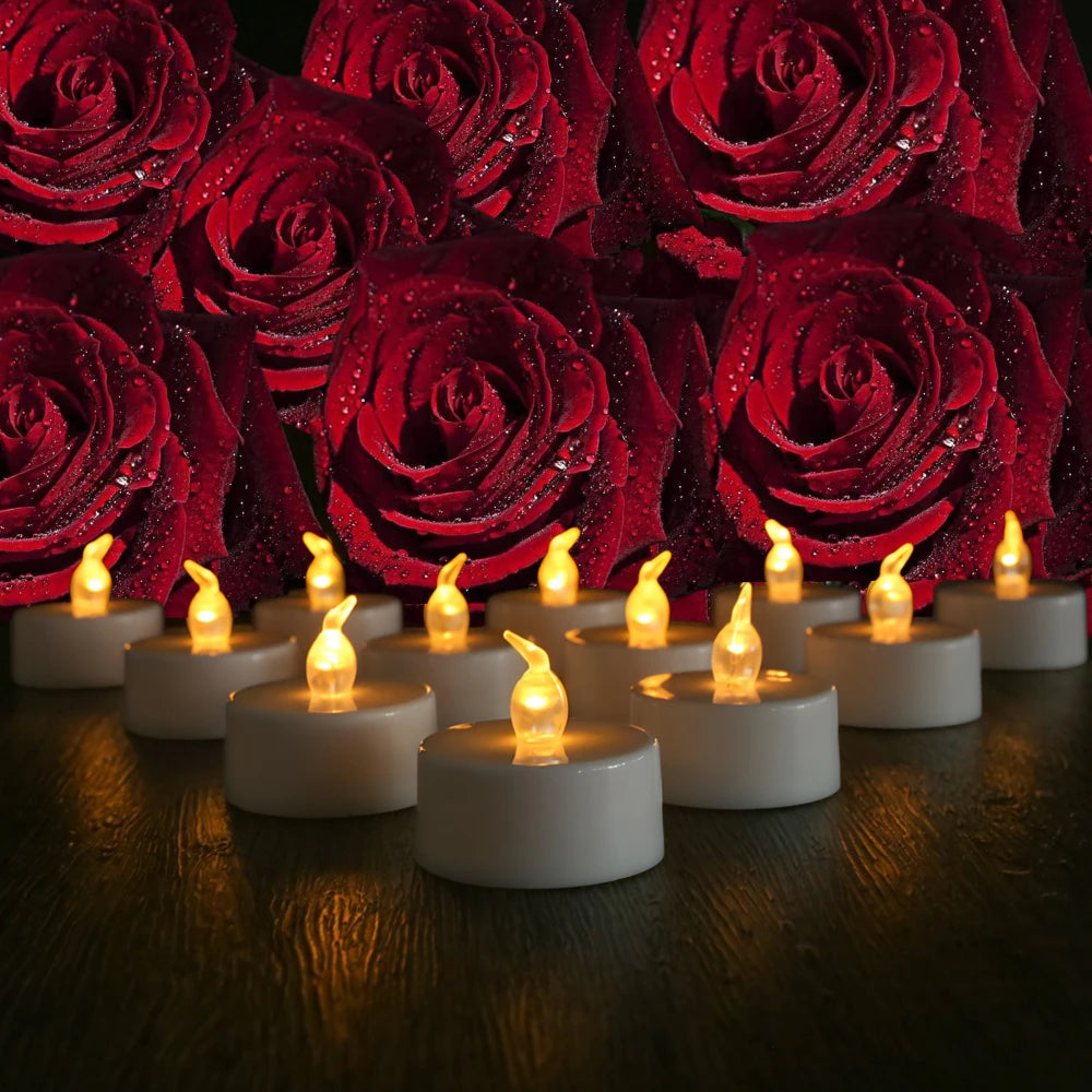 A close-up of glowing LED tea light candles set on a dark wooden surface, surrounded by red roses.