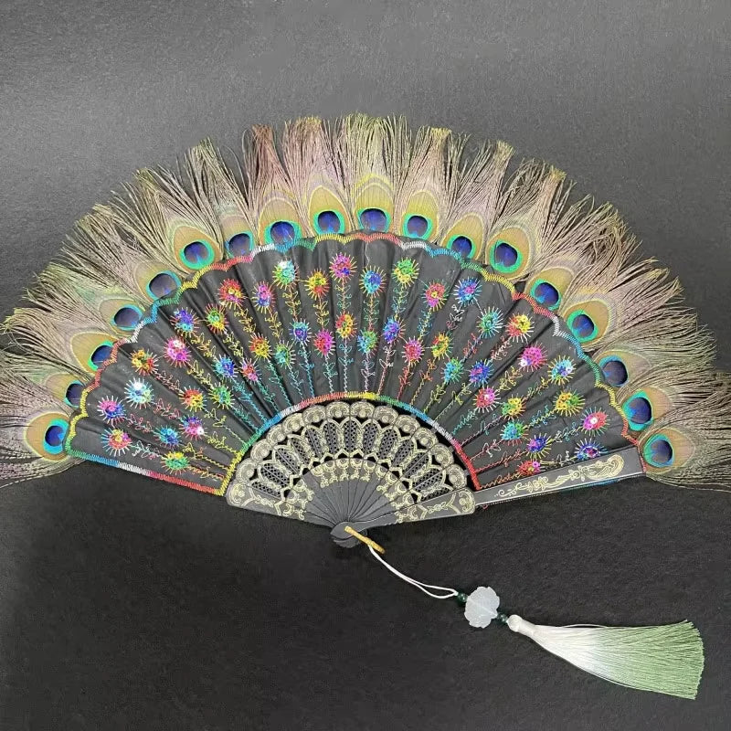 Un éventail à main en plume de paon naturelle avec des plumes irisées et une base gris foncé.