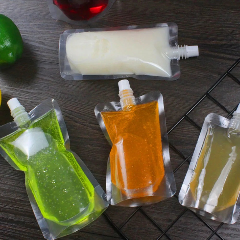 Several clear plastic pouches contain various colored liquid drinks like green orange and yellow