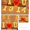 A display of warm white LED alphabet letter lights forming the number 314 and the letter U, arranged on a white fluffy surfac