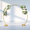 A gold-framed wedding arch decorated with white roses and green eucalyptus leaves.