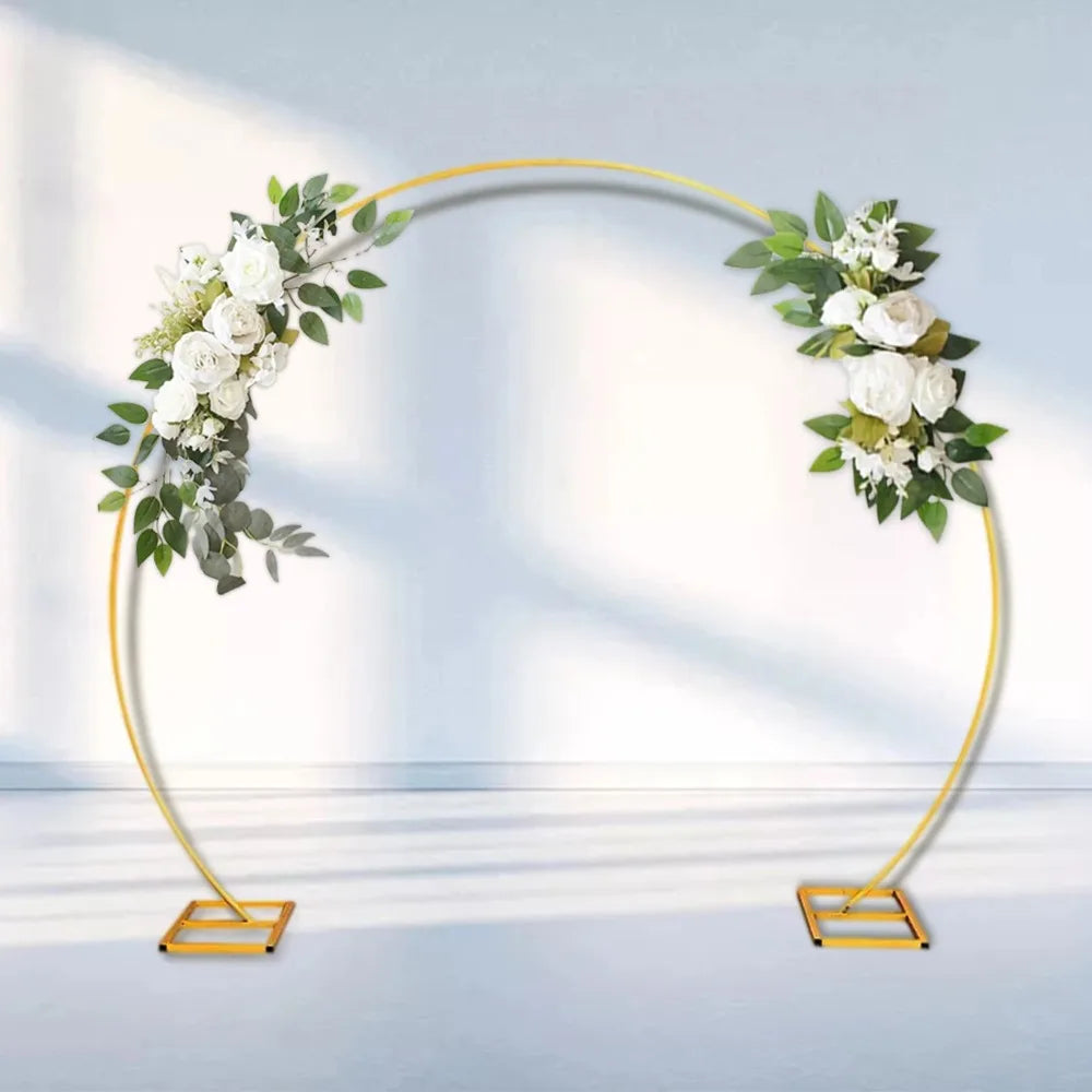 A gold-framed wedding arch decorated with white roses and green eucalyptus leaves.