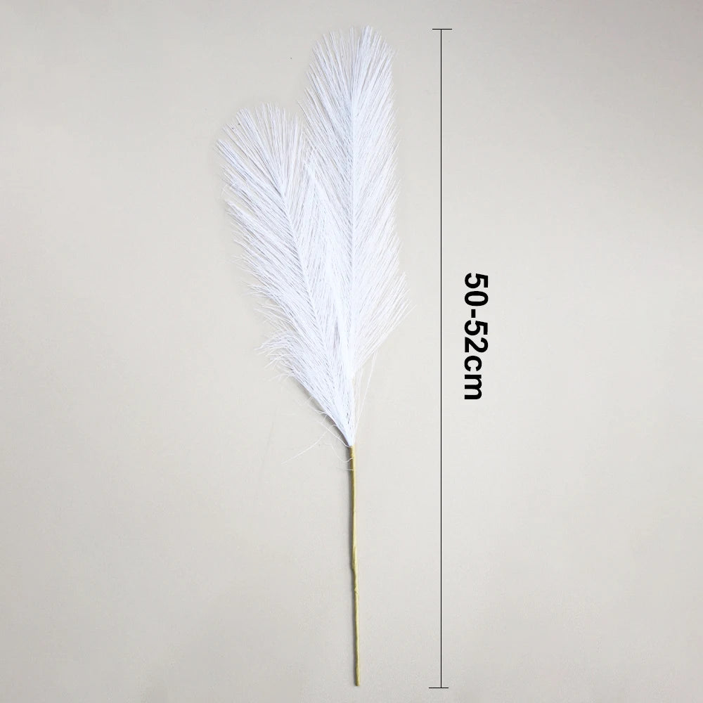 A white faux pampas grass feather displayed against a neutral background with a measurement scale.