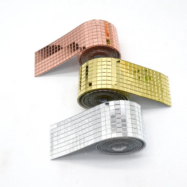 Tres rollos de azulejos de mosaico de espejo 3D en tonos oro rosa, dorado y plata, mostrados en diagonal.