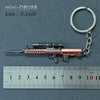 A miniature realistic alloy gun model keychain with a metallic finish, shown next to a ruler.