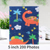 A dark blue fabric square featuring colorful cartoon dinosaurs and tropical leaves for a memory album.
