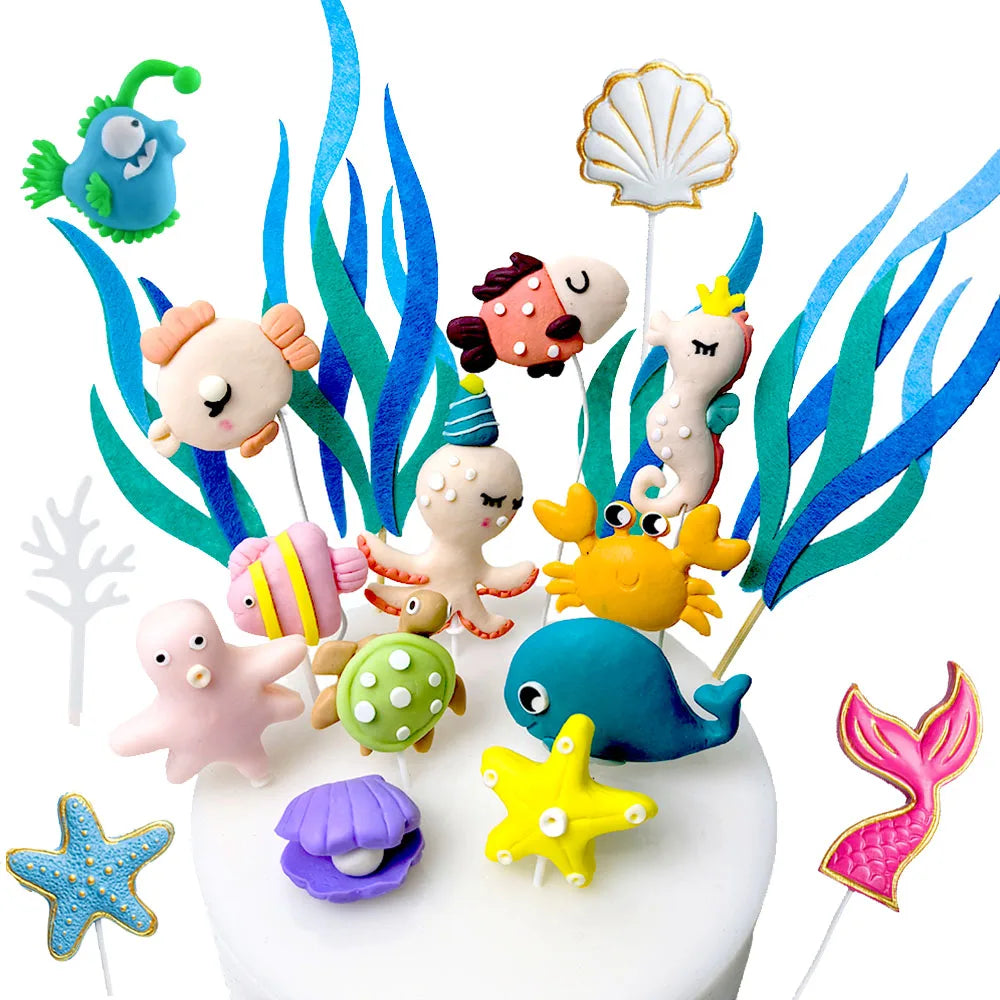 A set of colorful ocean animal cake toppers including a crab, turtle, octopus, whale, starfish, and shell decor.