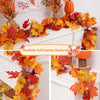 Realistic fall leaves garland featuring vibrant orange, red, and yellow maple leaves decorating a white mantelpiece.