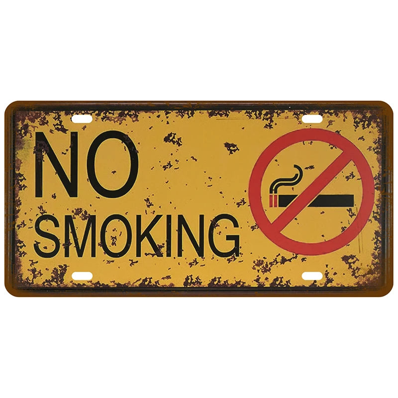 A vintage, distressed metal tin sign with the text NO SMOKING and a red circle prohibition symbol on a mustard yellow backgro