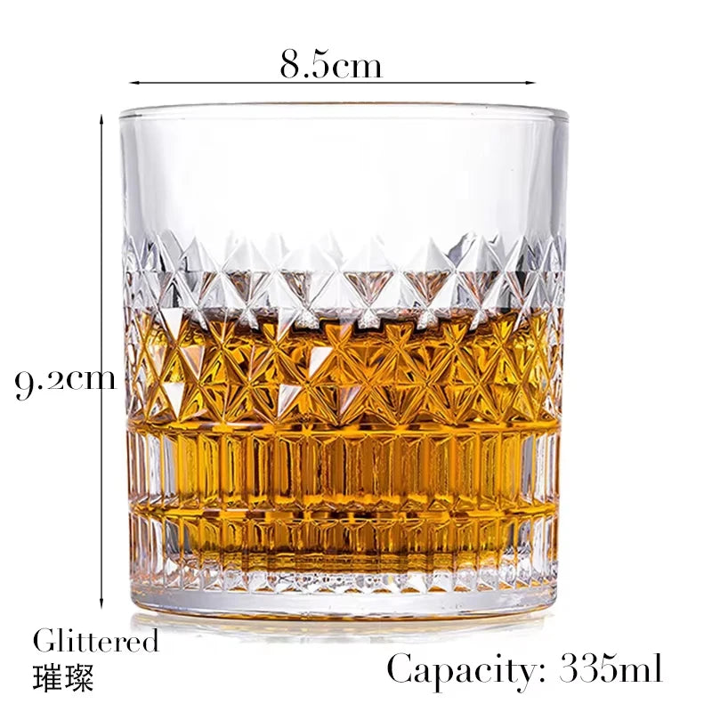 A clear whiskey glass filled with amber liquid, featuring a textured pattern and a glittered rim.