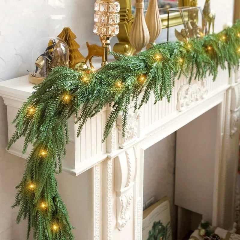 Green Norfolk pine Christmas garland with warm lights draped over a white fireplace mantel