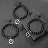 Black beaded zodiac bracelets and necklaces with gold accents displayed on a dark surface.