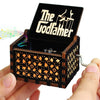 A carved wooden music box with an open lid revealing a silhouette of a figure and musical notes.