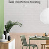 A modern kitchen setting featuring light wood cabinetry, a green chair, and white textured wall panels.