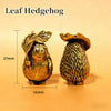 A small brass leaf hedgehog statue with textured body and leaves, shown against a light background.
