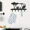 Black silhouette decorative metal key hooks mounted on a white wall above a blue patterned fabric.
