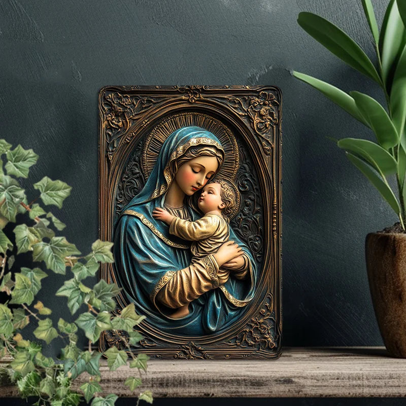 A bronze-colored metal sign depicting the Virgin Mary holding the infant Jesus in a detailed religious artwork.
