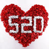 A heart-shaped arrangement made of red and silver silk rose petals.