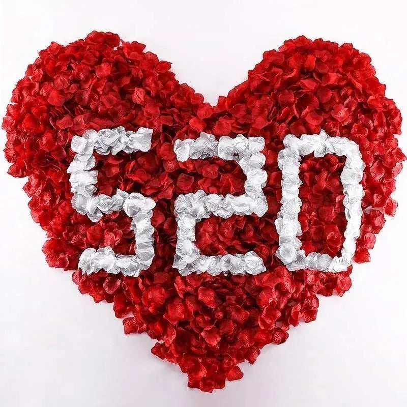 A heart-shaped arrangement made of red and silver silk rose petals.