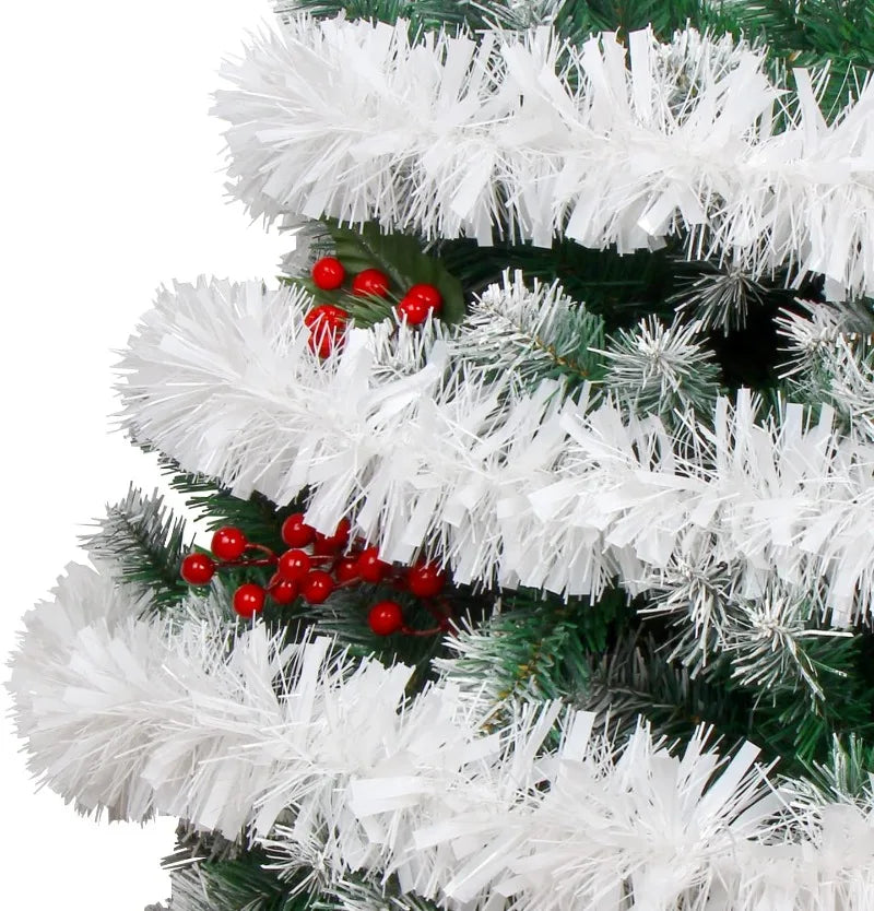 A close-up of a Christmas tree decorated with white tinsel ribbon garland and red berries.