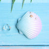 Light blue seashell decor featuring a starfish and pearl on a wooden surface.