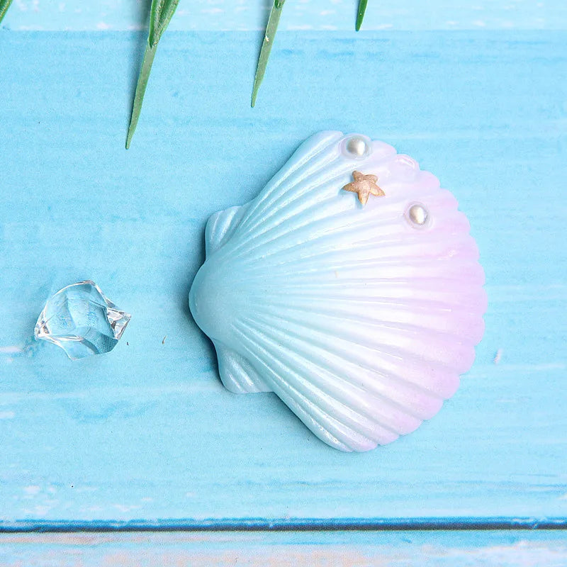 Light blue seashell decor featuring a starfish and pearl on a wooden surface.