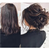 Gros plan sur les cheveux noirs d'une femme coiffés en chignon décoiffé avec des élastiques synthétiques.