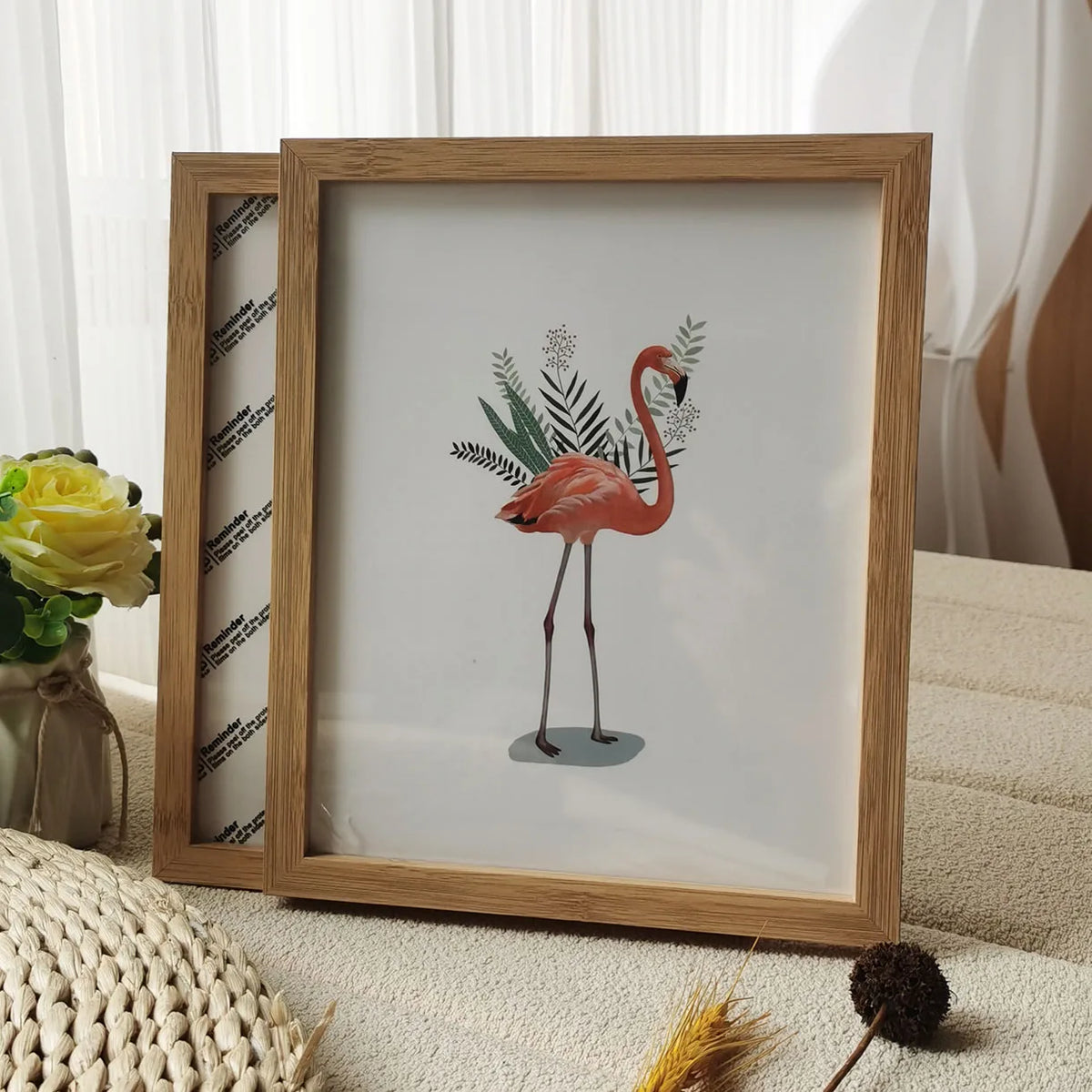 A wooden photo frame displaying a watercolor illustration of a pink flamingo on a light background.