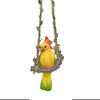Handmade resin climbing monkey figurine with yellow and orange feathers hanging from a branch