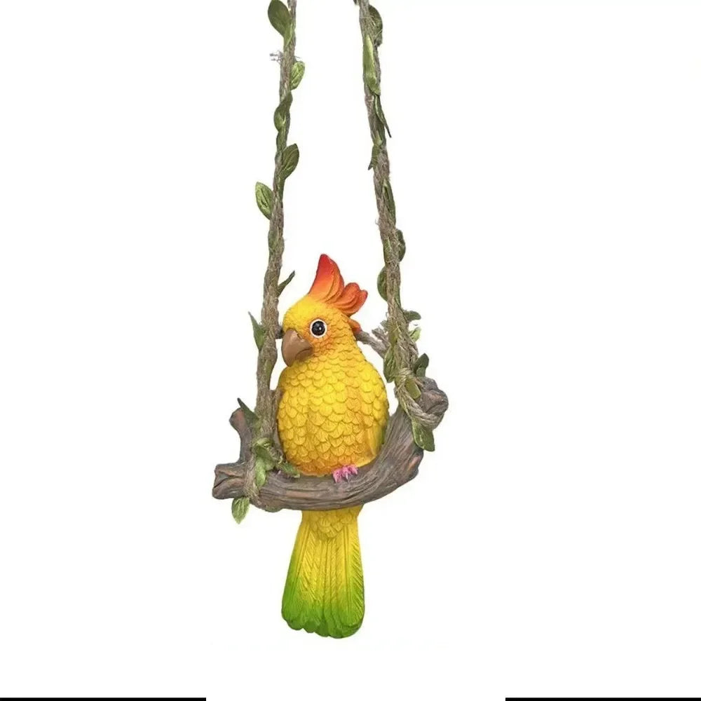 Handmade resin climbing monkey figurine with yellow and orange feathers hanging from a branch