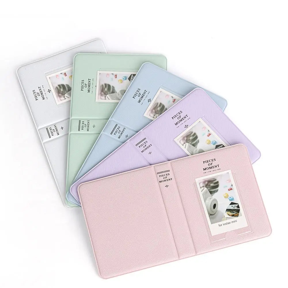 A set of five pastel-colored photo albums for instant cameras, including pink, mint green, light blue, and lavender.