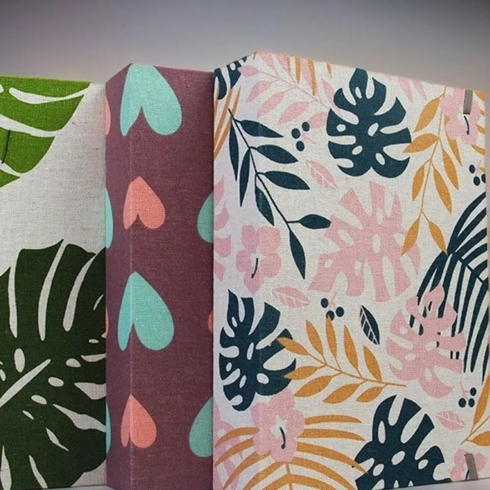 Primer plano de un álbum de recortes de tela con patrones florales en tonos verdes, rosa y turquesa.